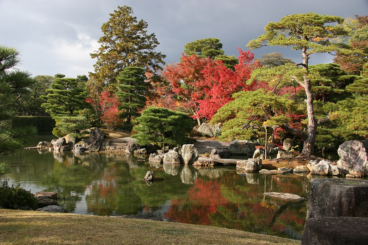 桂離宮天橋立一帶的池岸、石組與水面，秋色樹木沿岸展開