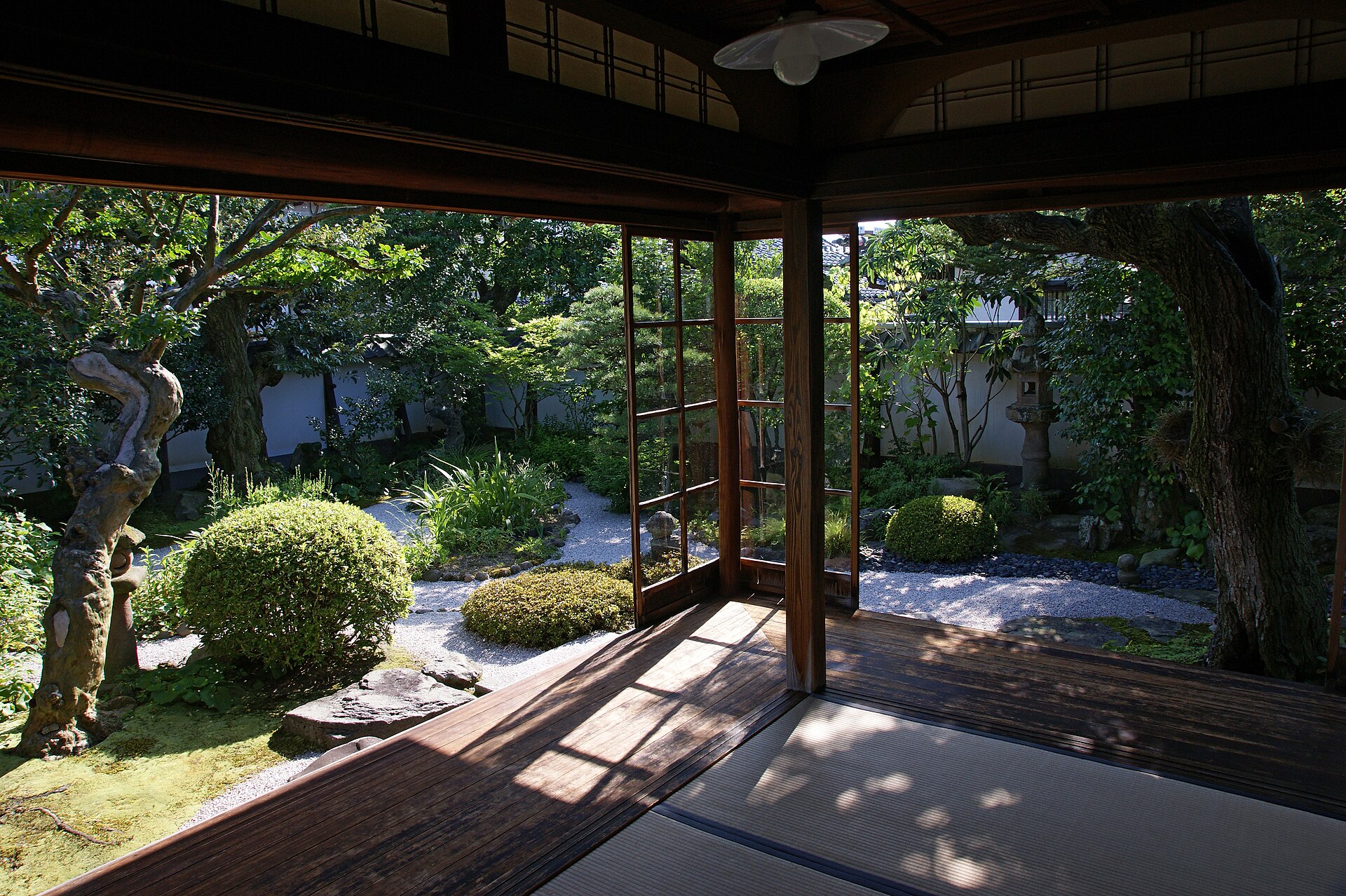 從松江小泉八雲舊居的緣廊望向庭園，榻榻米、木柱、樹木與石燈籠相連